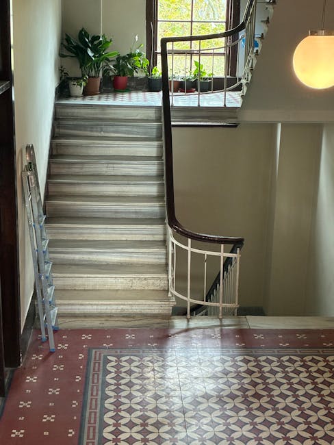 Close-up of two decorative rugs on a polished wooden floor in a residential setting, with one rug featuring a traditional geometric pattern in red, blue, and beige, and the other in muted tones with i